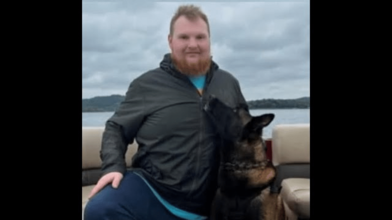 A man and his dog sitting on the back of a boat.