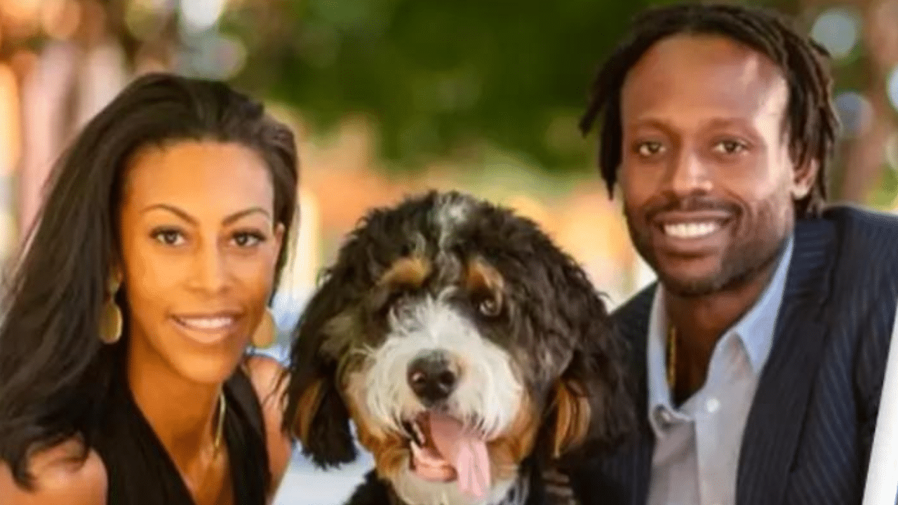 A man and woman standing next to a dog.