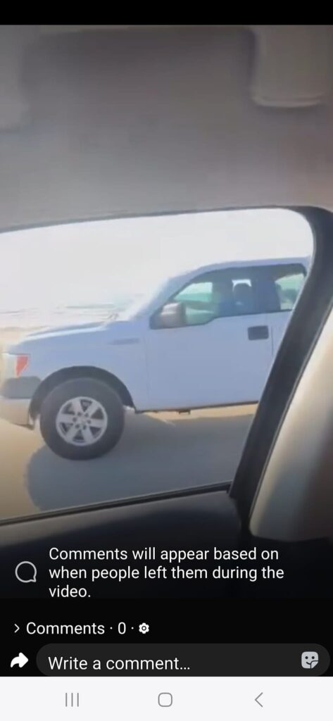 A white truck is driving down the street