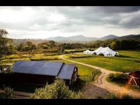 A view of a farm with tents in the background.