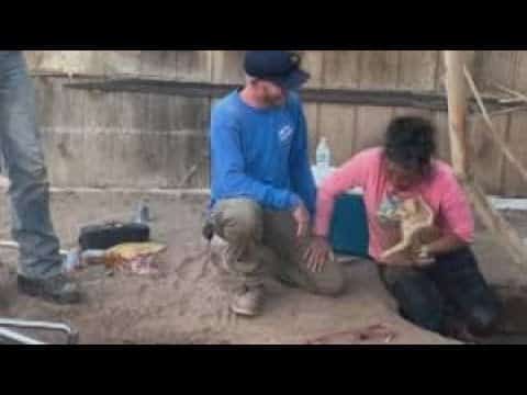 A man and woman sitting on the ground.