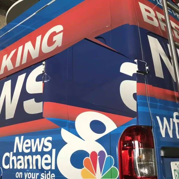 A news channel bus with the logo of nbc and 8-bit.