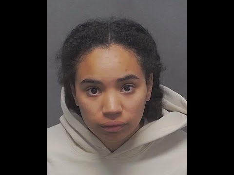 A woman with brown hair and a white hoodie.