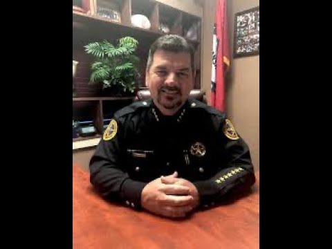 A man in police uniform sitting at a table.