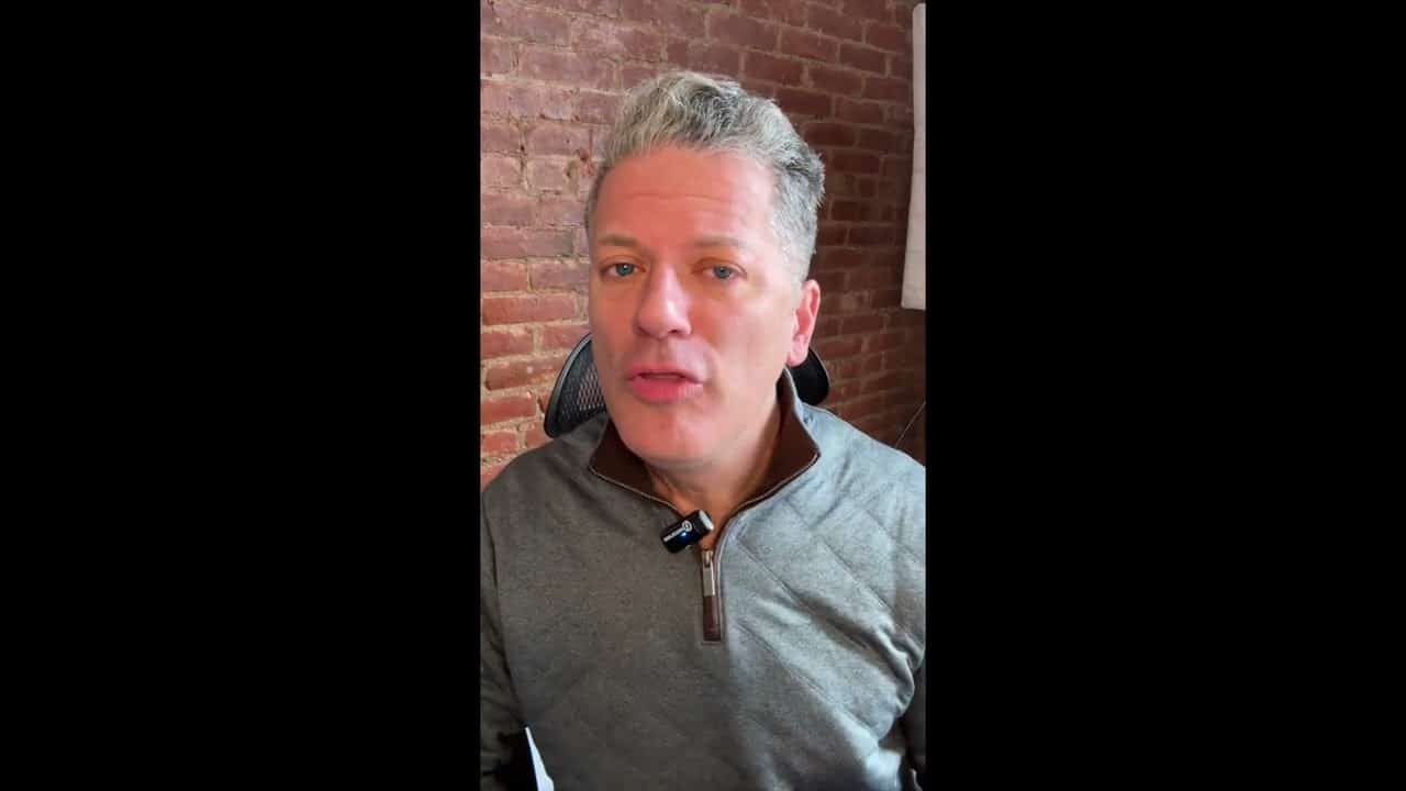 A man with gray hair is wearing a jacket.