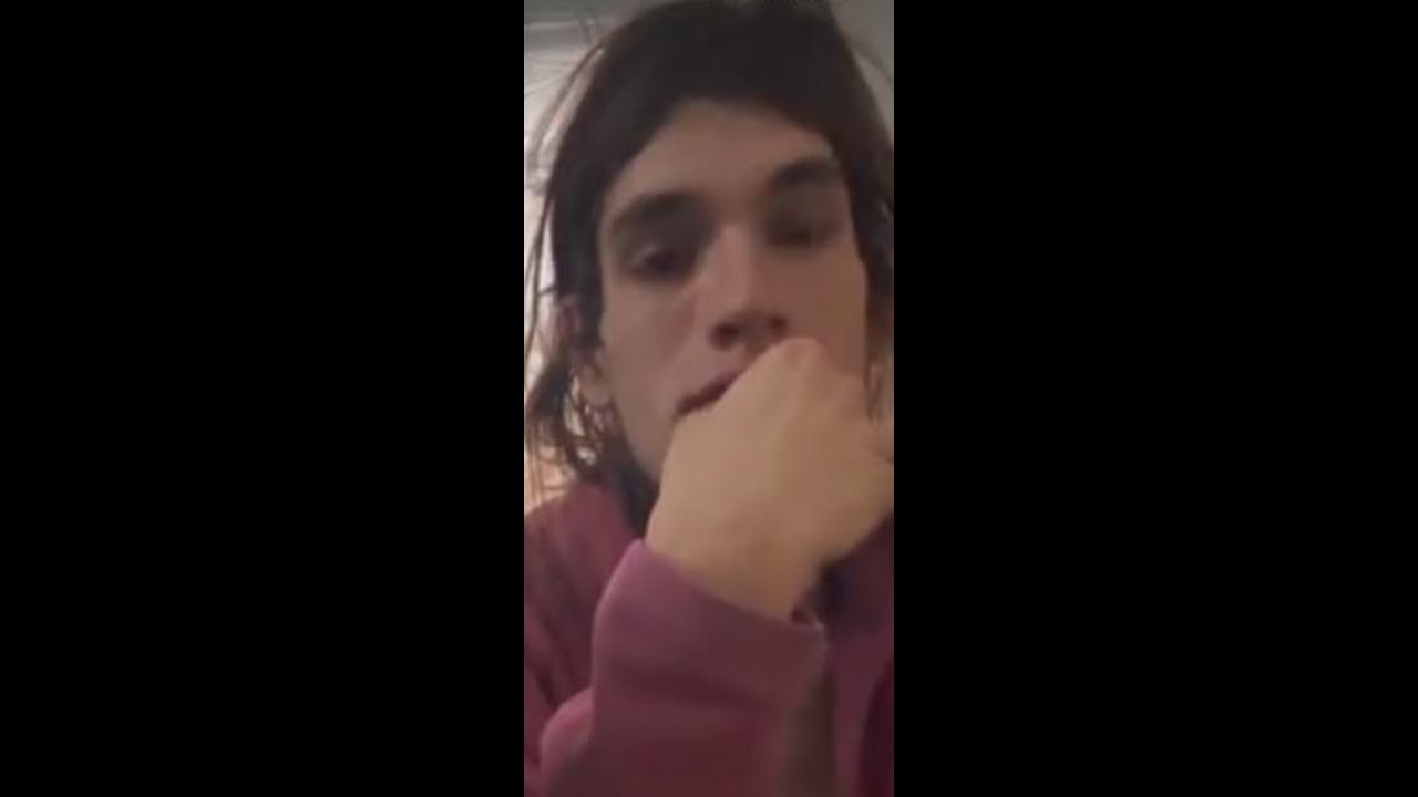 A man with long hair is sitting down