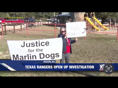 A woman holding signs in front of a park.