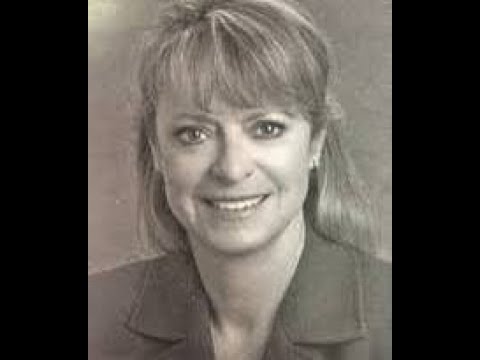 A black and white photo of a woman smiling.