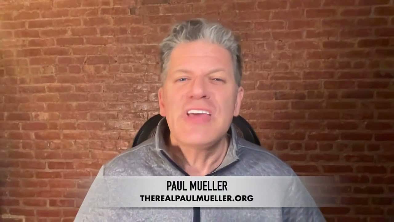 A man with grey hair is wearing a gray jacket.