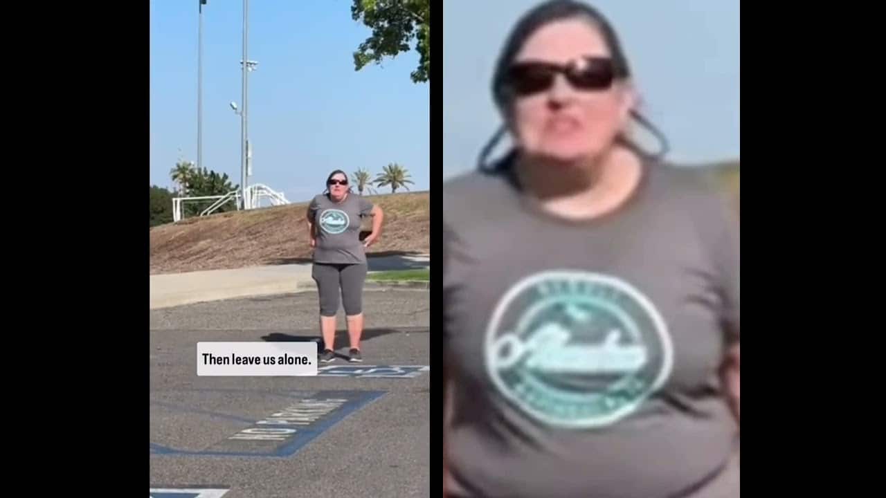 A woman standing in front of a sign and another person wearing sunglasses.
